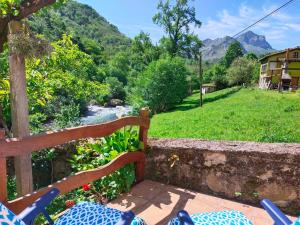 a wooden bench sitting next to a river at Loft Miradas al Sella in Corigos +2 photos