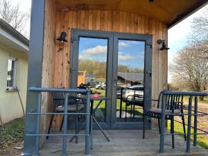 a patio with two chairs and a table and glass doors at Tiny Haus roter Wagen in Langenselbold