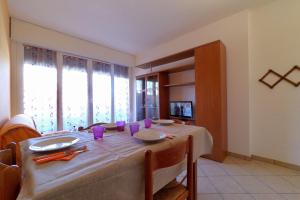 a dining room with a table with a white table cloth at Appartamenti Eco del Mare in Lido di Pomposa