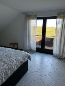 a bedroom with a bed and a large window at Oak Wood Ranch Guest Apartment in Marsberg