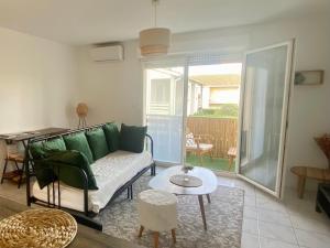 a living room with a couch and a table at Porte de Saint Emilion in Coutras