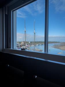 a window view of a harbor with boats in the water at Stay at Plattens in Wells next the Sea