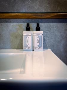 two bottles ofodorizers sitting on top of a white table at Stay at Plattens in Wells next the Sea +118 photos