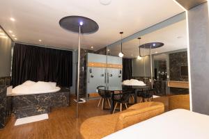 a room with a table and chairs and a bedroom at Motel Sedución (Adults only) in Cascavel