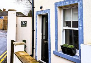 a blue and white building with a window at Hope Cottage in Hythe