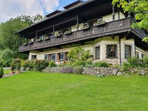a house with a balcony on top of a yard at Ferienwohnung Alpenvilla in Bischofswiesen