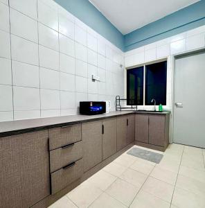 a kitchen with a counter with a microwave and a window at Cloud Nine Homestay in Tanah Rata