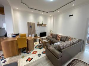 a living room with a couch and a table at Guest House Nuhellari - Family stay & Breakfast near Osumi Canyons in Çorovodë
