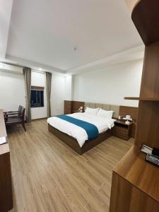 a bedroom with a large bed and a desk at Cheng Hotel - 怀庄酒店 in Hòa Ðình
