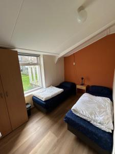 a bedroom with two beds and a window at T Skûttegat in Hollum