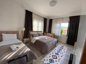a hotel room with two beds and a window at Guest House Nuhellari - Family stay & Breakfast near Osumi Canyons in Çorovodë