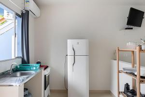 a kitchen with a refrigerator and a sink at Chalés do Mako in São Sebastião