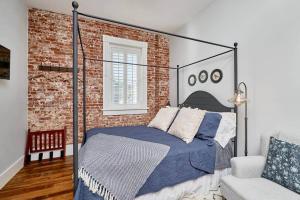 a bedroom with a bed and a brick wall at Studio 1892 Guesthouse in Hermann