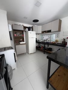 a kitchen with white cabinets and a refrigerator at Pousada e Hostel Natal in Natal
