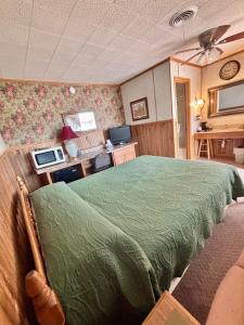 a bedroom with a bed with a green comforter at Starlite Motel in Seneca