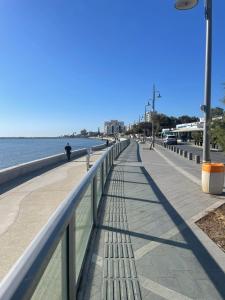 a bench on a sidewalk next to the water at Seaside Studio in Larnaca