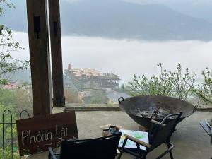 a large wheelbarrow sitting on a patio with a view at Phỏng Lài Mountain Homestay - Ta Xua Peak View in Bắc Yên