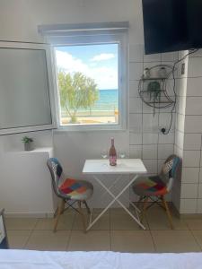 a kitchen with a table and two chairs and a window at Seaside Studio in Larnaca