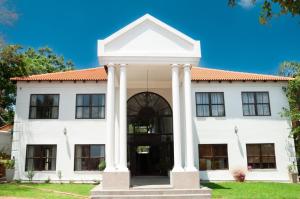 a white building with columns at Miyanwe Guest House - Waterkloof in Pretoria