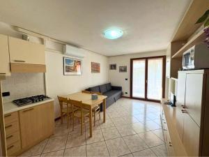 a kitchen and living room with a table and a couch at Alessia in Grado +14 photos