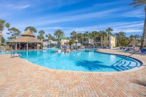 a swimming pool at a resort with palm trees at Island House 1Bu By Pkrm in Pensacola