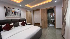 a bedroom with a large white bed with red pillows at Hillgates Apartments Ikeja in Ikeja +78 photos