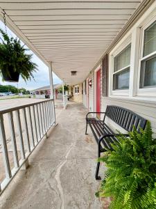 a bench sitting on the porch of a house at Starlite Motel in Seneca +4 photos