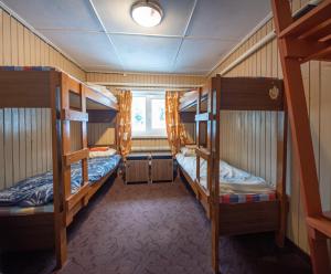 a room with three bunk beds and a window at Mõedaku Puhkekeskus in Mõedaka