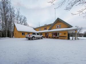 a house with a white truck parked in the snow at Mõedaku Puhkekeskus in Mõedaka