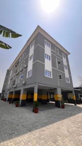 a large gray building with yellow and black stripes at Hillgates Apartments Ikeja in Ikeja