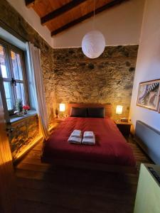 a bedroom with a red bed with two towels on it at CasaLambra Pedoulas Exclusive Accomodation Troodos Mountains in Pedoulas