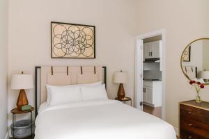 a bedroom with a white bed and a mirror at LIVN Millennium Park Downtown Chicago Superior 2 BR in Chicago
