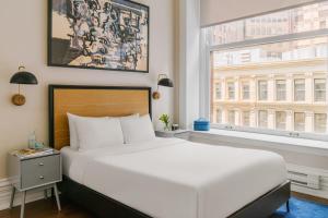 a bedroom with a large white bed and a window at LIVN Millennium Park Downtown Chicago Superior 2 BR in Chicago
