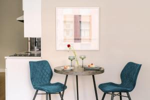 a dining room table with two chairs and a table with a vase at LIVN Millennium Park Downtown Chicago Superior 2 BR in Chicago +10 photos