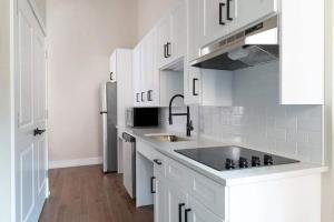 a white kitchen with a sink and a refrigerator at LIVN Millennium Park Downtown Chicago Superior 2 BR in Chicago