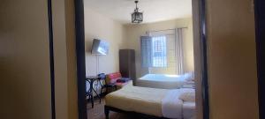 a small room with two beds and a window at Peter's Hostel in Arequipa