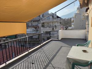 a balcony with a table and chairs on a building at A & P Apartment in Xanthi