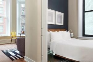 a bedroom with a bed and a chair and a desk at LIVN Millennium Park Downtown Chicago Superior 1BR in Chicago