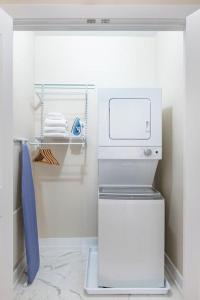 a small white refrigerator in a white kitchen at LIVN Millennium Park Downtown Chicago Superior 1BR in Chicago