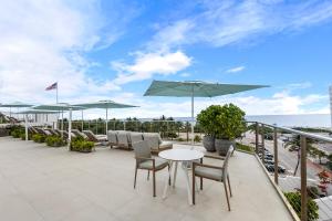 a patio with chairs and a table and umbrella at Bentley Hotel South Beach in Miami Beach