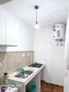 a white kitchen with a sink and a stove at Casa Perla zamba in Cerrillos