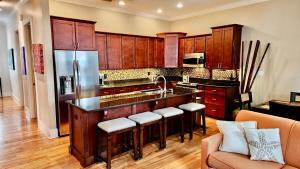 a kitchen with wooden cabinets and a kitchen island with bar stools at Coastal Dunes Escape in Santa Rosa Beach