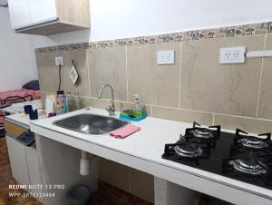 a kitchen counter with a sink and a stove at Casa Perla zamba in Cerrillos