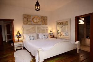 a bedroom with a white bed and a mirror at Araújo Bazilio Pousada Tiradentes in Tiradentes +80 photos