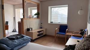 a bedroom with a bed and a desk and a chair at Købmandsgården 1 in Sæby