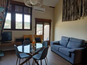 a living room with a couch and a table and chairs at Casa del Caballo - Housevanlive in Casas Altas