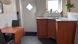 a kitchen with a sink and a table and a window at Købmandsgården 1 in Sæby +2 photos