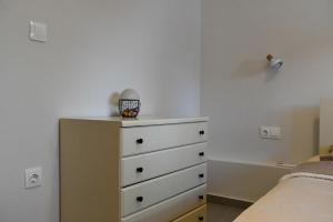 a bedroom with a bed and a dresser with a dresser at Everlong Boutique Home in Nea Michaniona