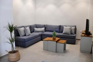a living room with a blue couch and a tv at Everlong Boutique Home in Nea Michaniona