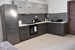 a kitchen with white cabinets and a stainless steel refrigerator at Everlong Boutique Home in Nea Michaniona +12 photos